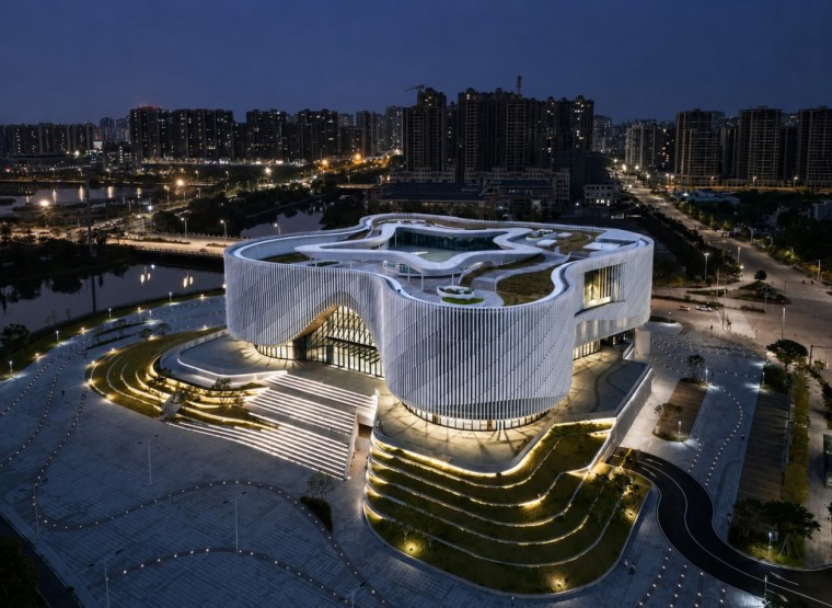 Night aerial view of Yangjiang Cultural Center with illuminated white terracotta fins