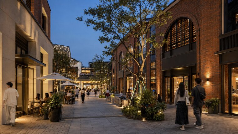 Evening pedestrian street with arched red brick facades